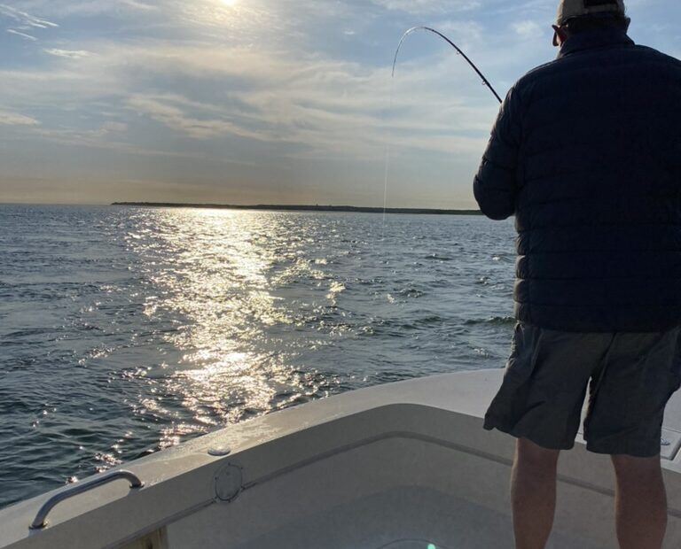 Sunrising over the water with a bent fishing rod