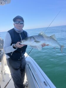 Capt Avery holding a striper on Another Busman's Holiday